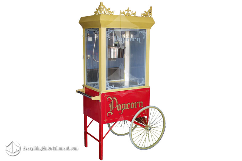 Gold popcorn machine and red wagon with wheels on white background.