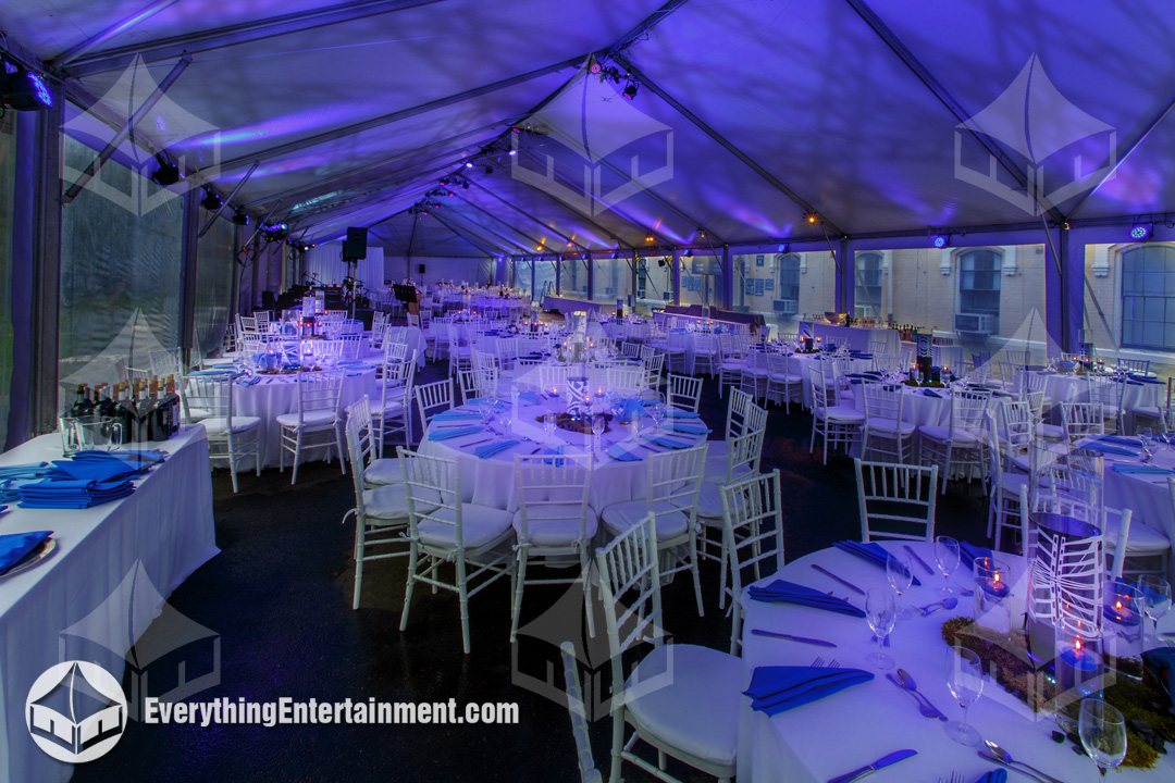 large tent with blue lights, projected patterns, and centerpiece pin spotti