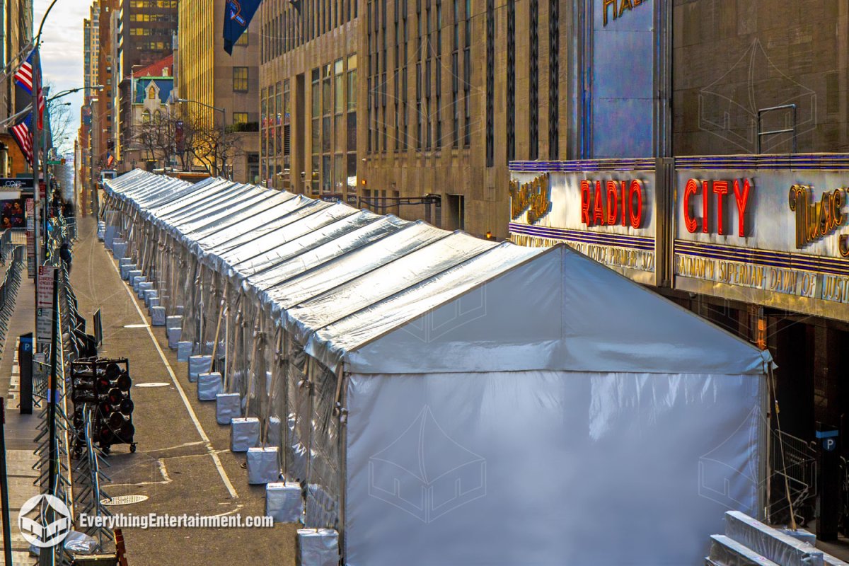 High-angle exterior view of a massive 20x500 frame tent with concrete ballasts and clear sidewalls stretching down the street past Radio City Music Hall in NYC for the Batman v. Superman movie premiere by Everything Entertainment.