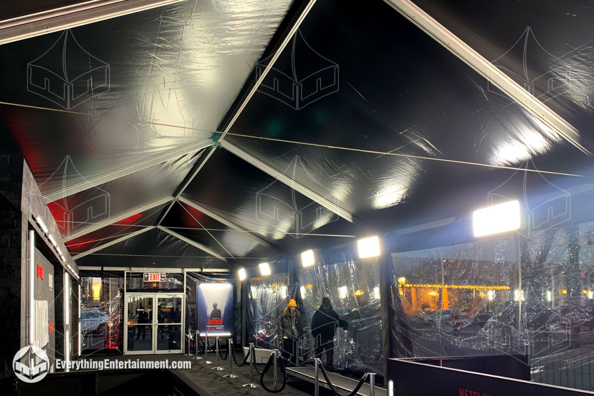 Interior view of a 20x60 black top maxi-frame tent with clear sidewalls, subfloor, and electric heaters installed by Everything Entertainment in front of the Pulitzer Fountain for the Luther movie premiere in NYC.