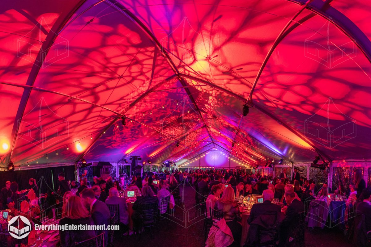 Interior shot showcasing intricate gobo lighting patterns and bistro string lights across the ceiling canopy of a 50x120 gala tent by Everything Entertainment