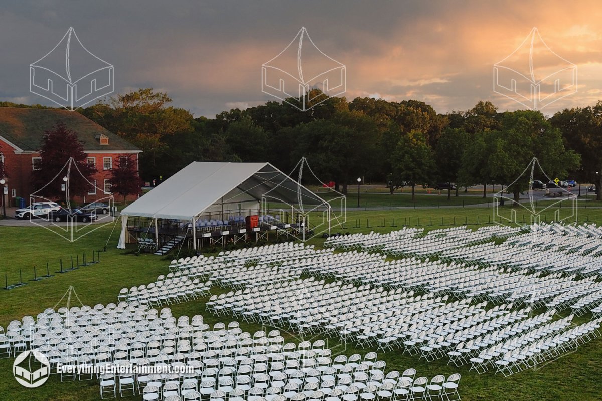 Aerial side perspective of a 50x30 open gable commencement stage tent facing vast rows of 6,500 audience chairs for a college graduation by Everything Entertainment.