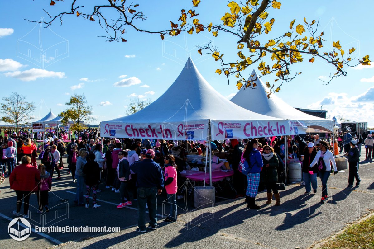 High peak check-in tent with Making Strides signage surrounded by walk participants on Staten Island by Everything Entertainment.