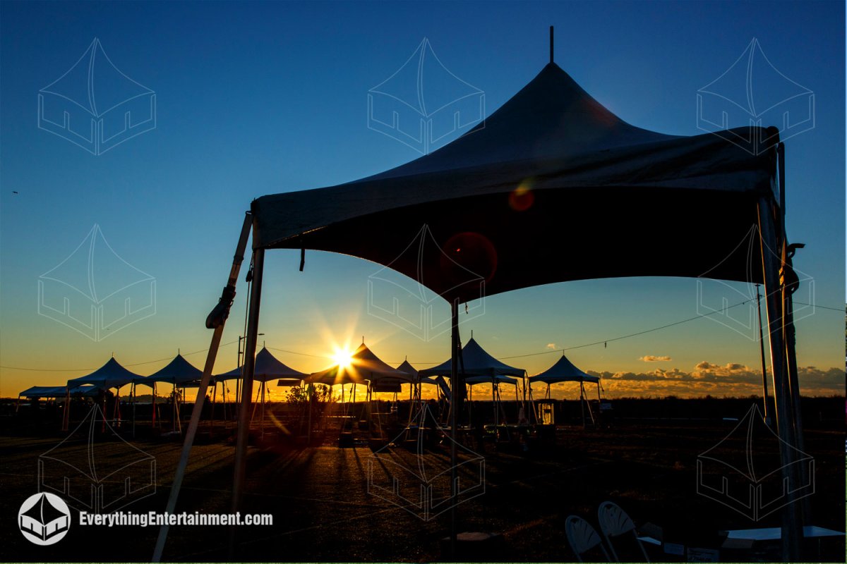 Row of high peak tents backlit by a sunrise for Making Strides Against Breast Cancer on Staten Island by Everything Entertainment.