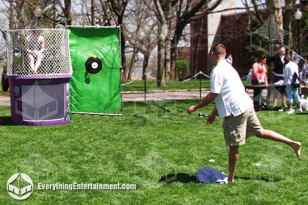 someone tossing ball at dunk tank with person in seat