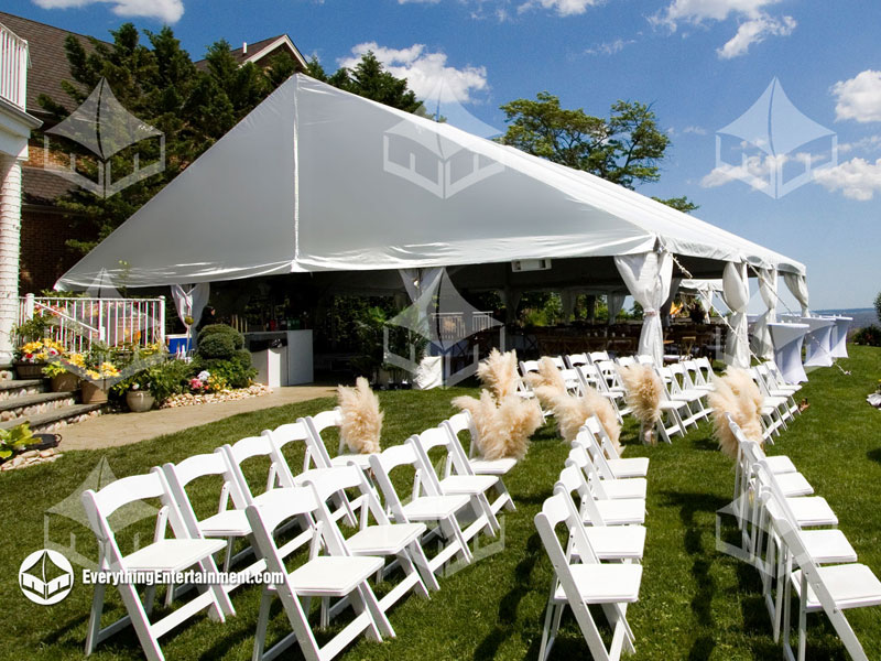 50x50 frame tent setup for a backyard wedding with ceremony chairs in foreground.