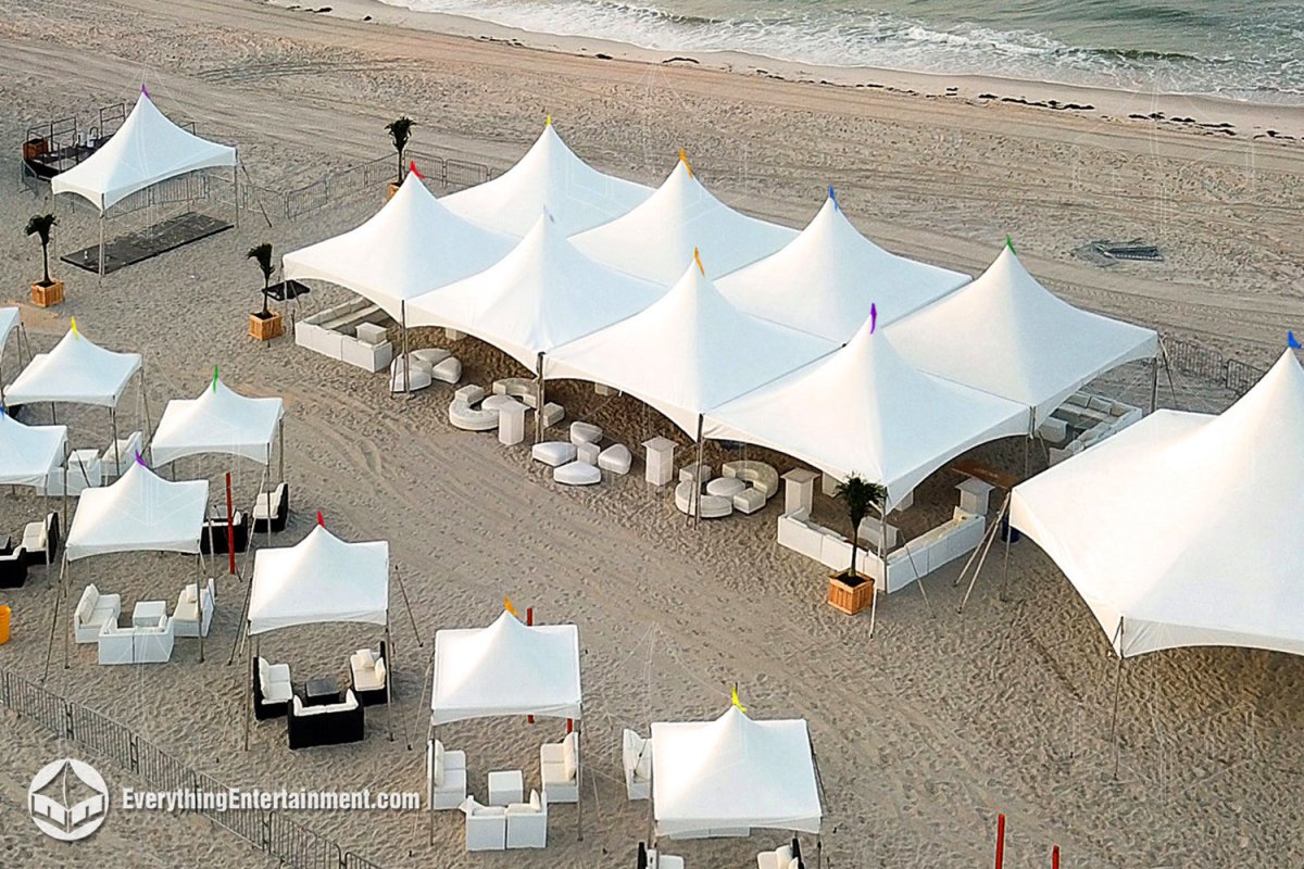 igh-angle aerial view of multiple white high-peak tents configured as VIP beach cabanas with lounge furniture for Pride on the Beach on Long Beach NY by Everything Entertainment.