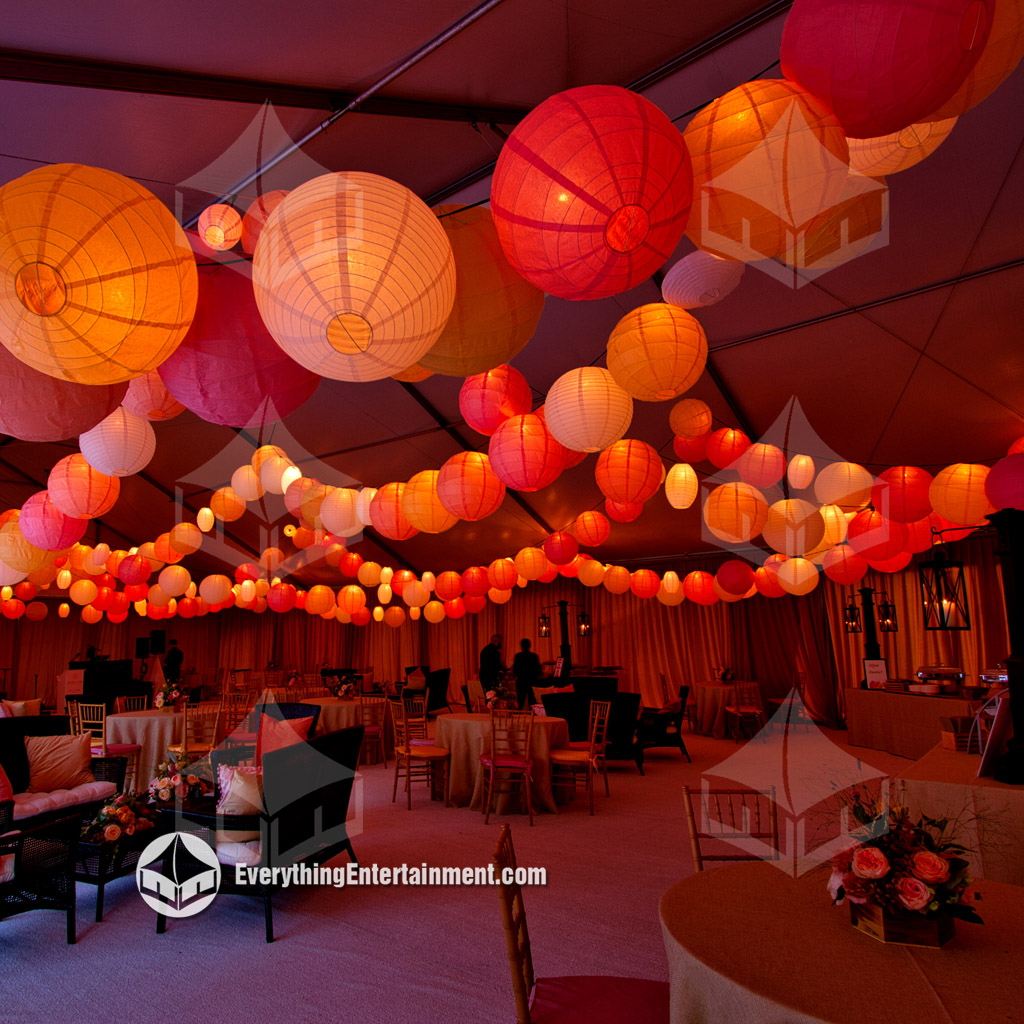 A large white wedding tent interior with colorful paper lanterns