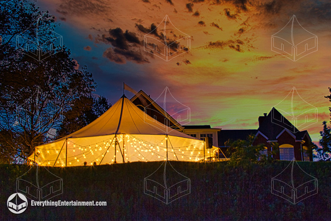 A sailcloth tent glowing in the night sky.