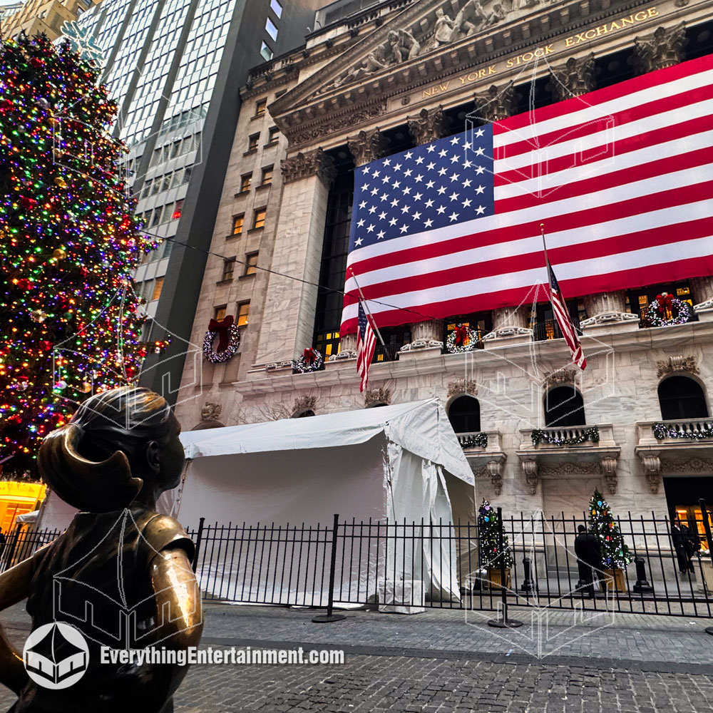 Frame Tent set up at the New York Stock Exchange with statue of Fearless Girl looking at American Flag