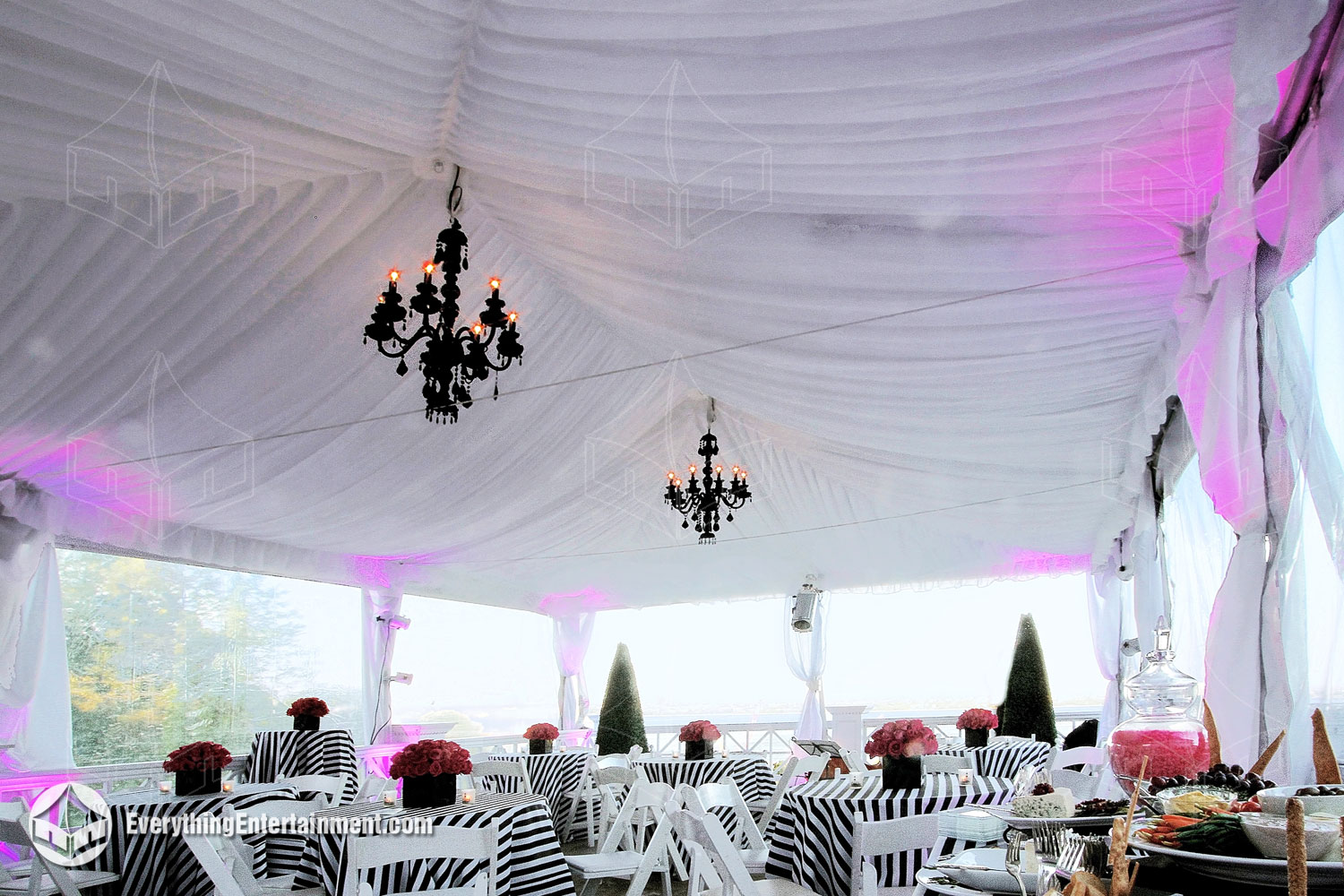 White fabric drapery inside a tent with black crystal chandeliers