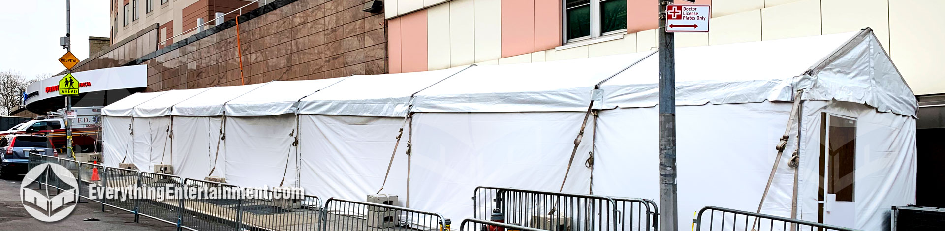 very long tent setup on sidewalk outside hospital for virus testing