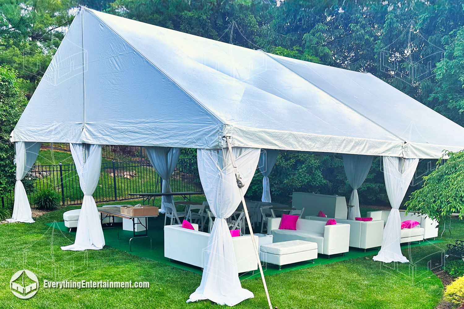 White fabric concealing tent legs in a tent with lounge furniture setup in a grassy backyard